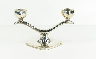 Lot 420 - A white metal double candlestick of curved...