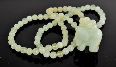 Lot 36 - A pale jade bead necklace, with elephant...