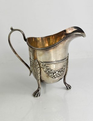 Lot 260 - A silver footed jug, embossed with floral...