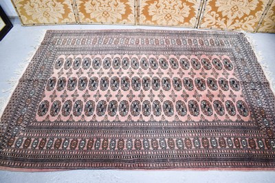 Lot 583 - A Middle Eastern rug with a peach ground, and...