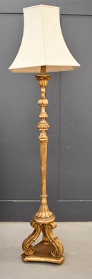 Lot 476 - A giltwood standard lamp with a fluted and...