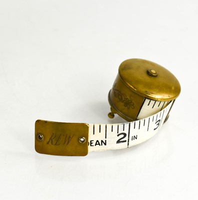 Lot 333 - A vintage brass tape measure with engraved...