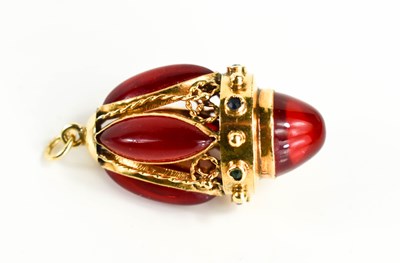 Lot 3 - A gold egg form pendant, set with red gemstone...