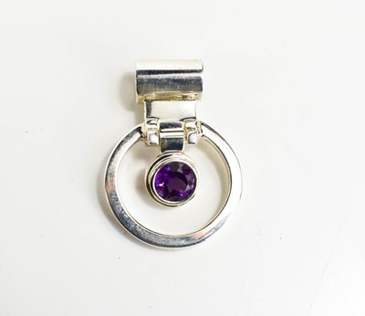 Lot 28 - A silver and amethyst set pendant of circular...