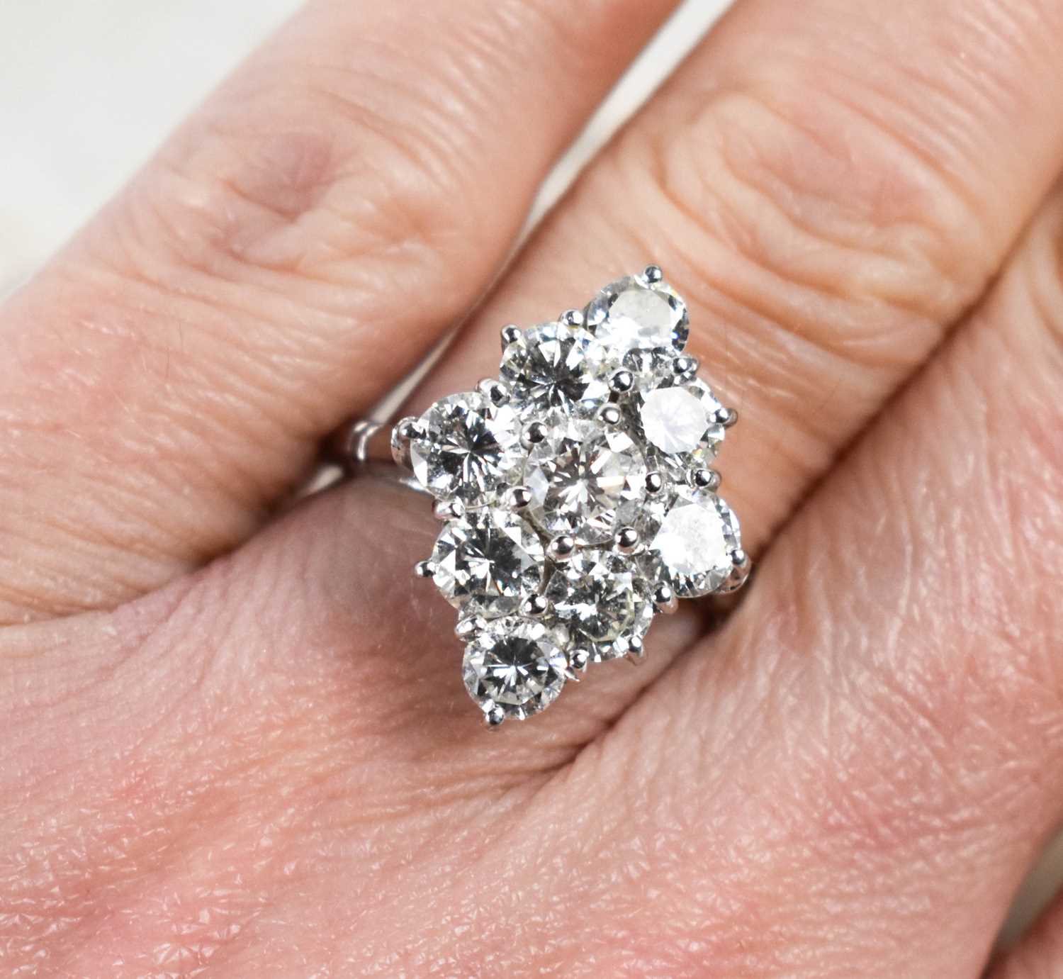 Lot 18 - A white gold and diamond ring set with nine...