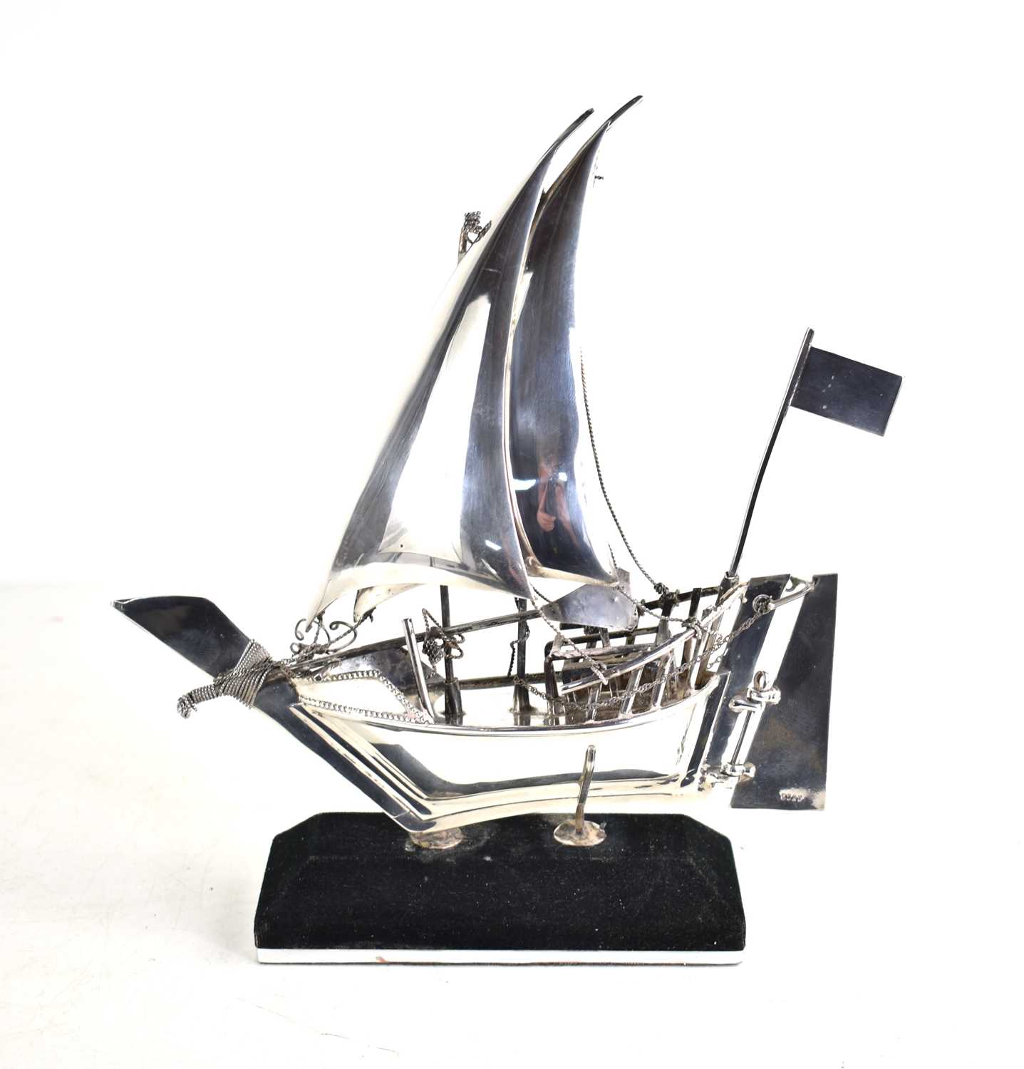 Lot 10 - A sterling silver model of a sailing boat on a...