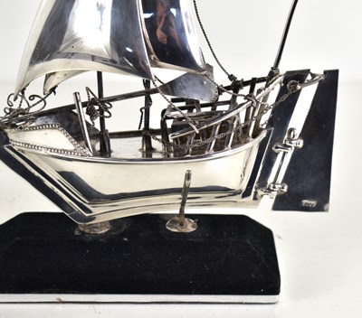 Lot 10 - A sterling silver model of a sailing boat on a...