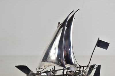 Lot 10 - A sterling silver model of a sailing boat on a...