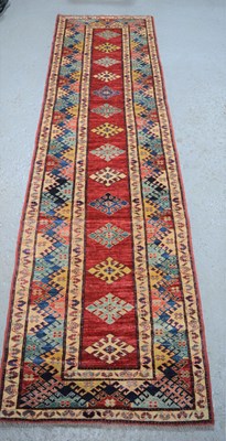 Lot 483 - A large wool runner with geometric stylised...