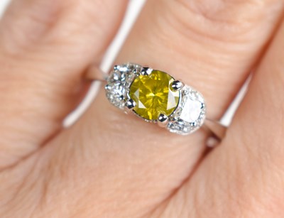 Lot 302 - A 14ct white gold three-stone ring set with a...