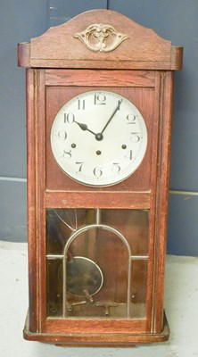 Lot 327 - A 1960s oak wall clock.