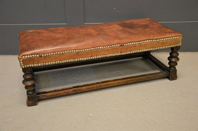 Lot 567 - An oak and leather top long stool with turned...