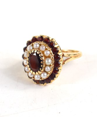 Lot 12 - A 14ct gold, seed pearl and garnet, oval form...