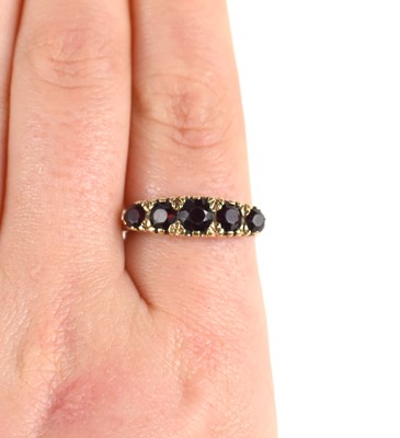 Lot 32 - A 9ct gold and garnet ring, the five graduated...