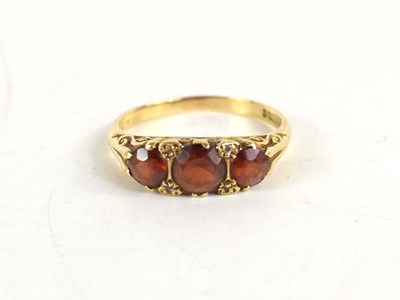 Lot 21 - A 9ct gold and garnet ring, the three...