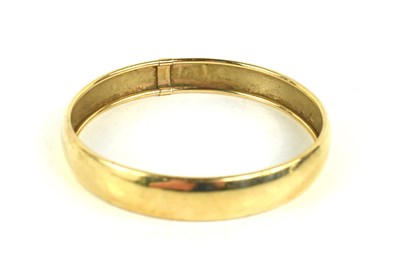 Lot 195 - A 9ct gold bangle, of rounded planished design,...