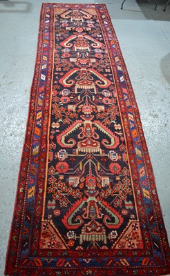 Lot 492 - A late 19th century runner, with a red ground,...