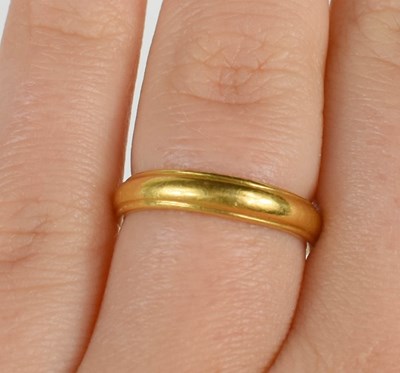 Lot 73 - A 22ct gold wedding band, size M, planished...