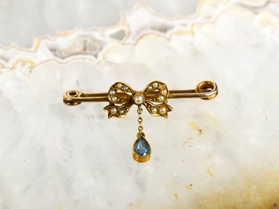 Lot 30 - A gold, seed pearl and blue topaz bar brooch,...