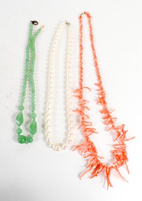 Lot 147 - A vintage coral necklace, a pale green jade...
