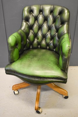 Lot 516 - A green button back reproduction swivel chair.