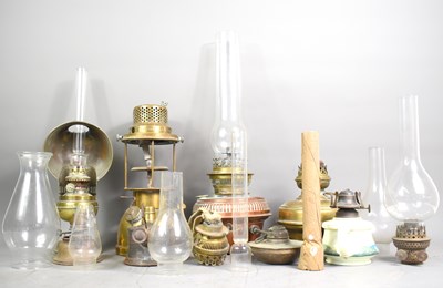 Lot 216 - A collection oil lamps, glass chimneys and...