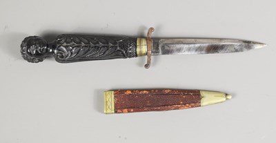 Lot 330 - An African dagger, the carved pommel in the...