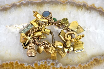 Lot 35 - A 9ct gold charm bracelet with twenty one...