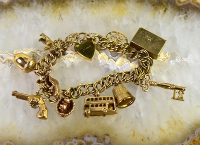 Lot 34 - A 9ct gold charm bracelet with ten charms to...