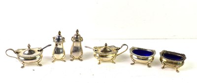 Lot 153 - Two silver three piece cruet sets, the salt...