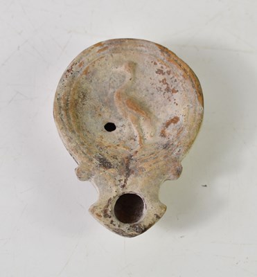 Lot 110 - A Roman terracotta round oil lamp with a...