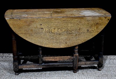 Lot 362 - An 18th century oak drop leaf table, with...