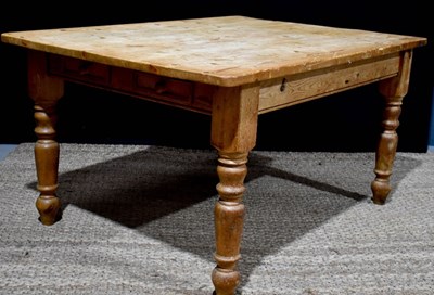 Lot 377 - A large antique pine kitchen table with boldly...