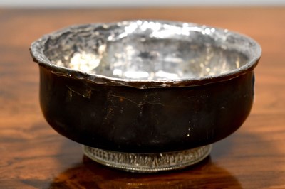 Lot 338 - A Tibetan treen and white metal libation bowl,...