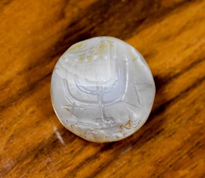 Lot 6 - An early carved agate roundel, carved to...