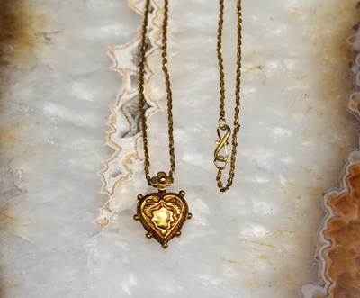 Lot 94 - An Indian gold heart form pendant on a gold...