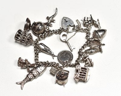 Lot 76 - A silver charm bracelet with seventeen charms...