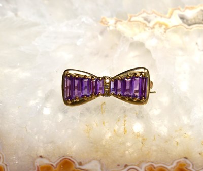 Lot 106 - A 9ct gold, amethyst and diamond bar brooch, 2....