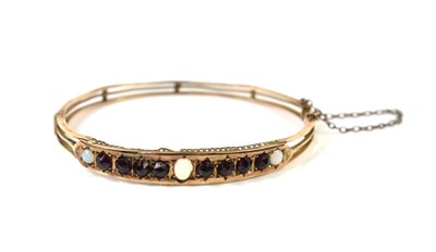 Lot 16 - An antique 9ct gold, opal and garnet hinged...