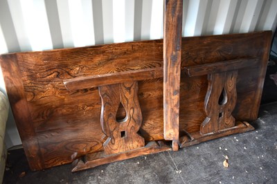 Lot 550 - A large oak trestle dining table, three plank...