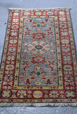 Lot 523 - A wool Kazak rug, blue and red ground with...