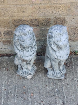 Lot 563 - A pair of lead style lion garden ornaments.