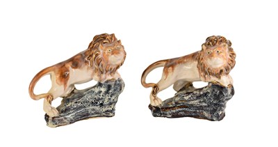 Lot 207 - A pair of 20th century pottery lions standing...