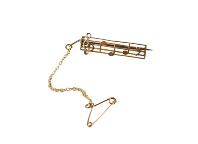 Lot 61 - A yellow metal bar brooch in the form of...