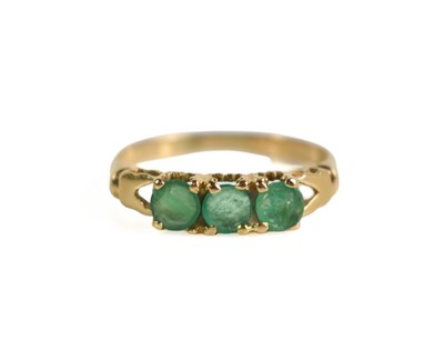 Lot 169 - An 18ct gold and emerald three stone ring, the...