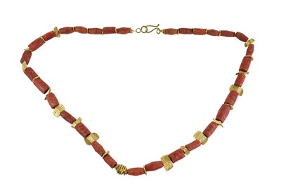 Lot 41 - A tubular coral bead and yellow metal shaped...