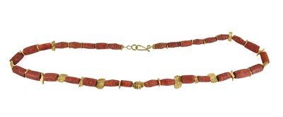 Lot 41 - A tubular coral bead and yellow metal shaped...