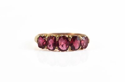 Lot 133 - A yellow metal and garnet ring, the five oval...