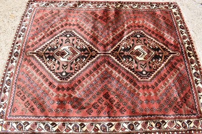Lot 433 - A Persian wool rug with red / brown ground,...