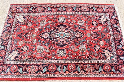 Lot 430 - A Persian wool rug with red ground, the...